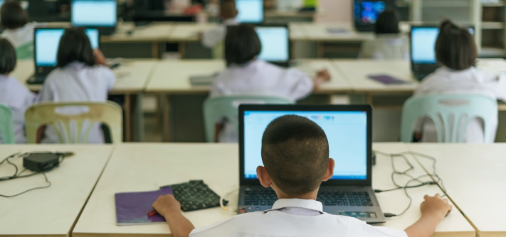 A classroom of children working on computers.