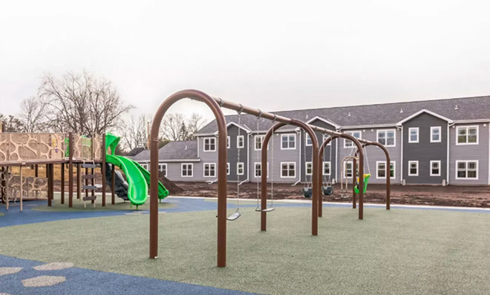 A playground outside of a housing development.