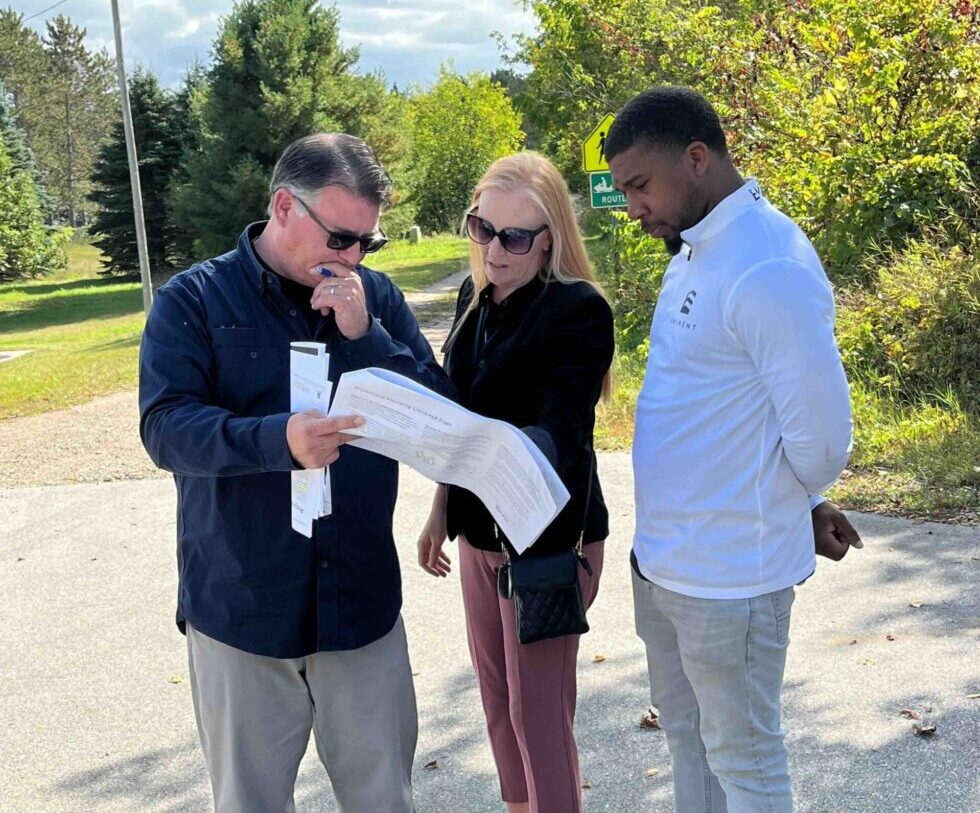 A group of three look at plans for a development.
