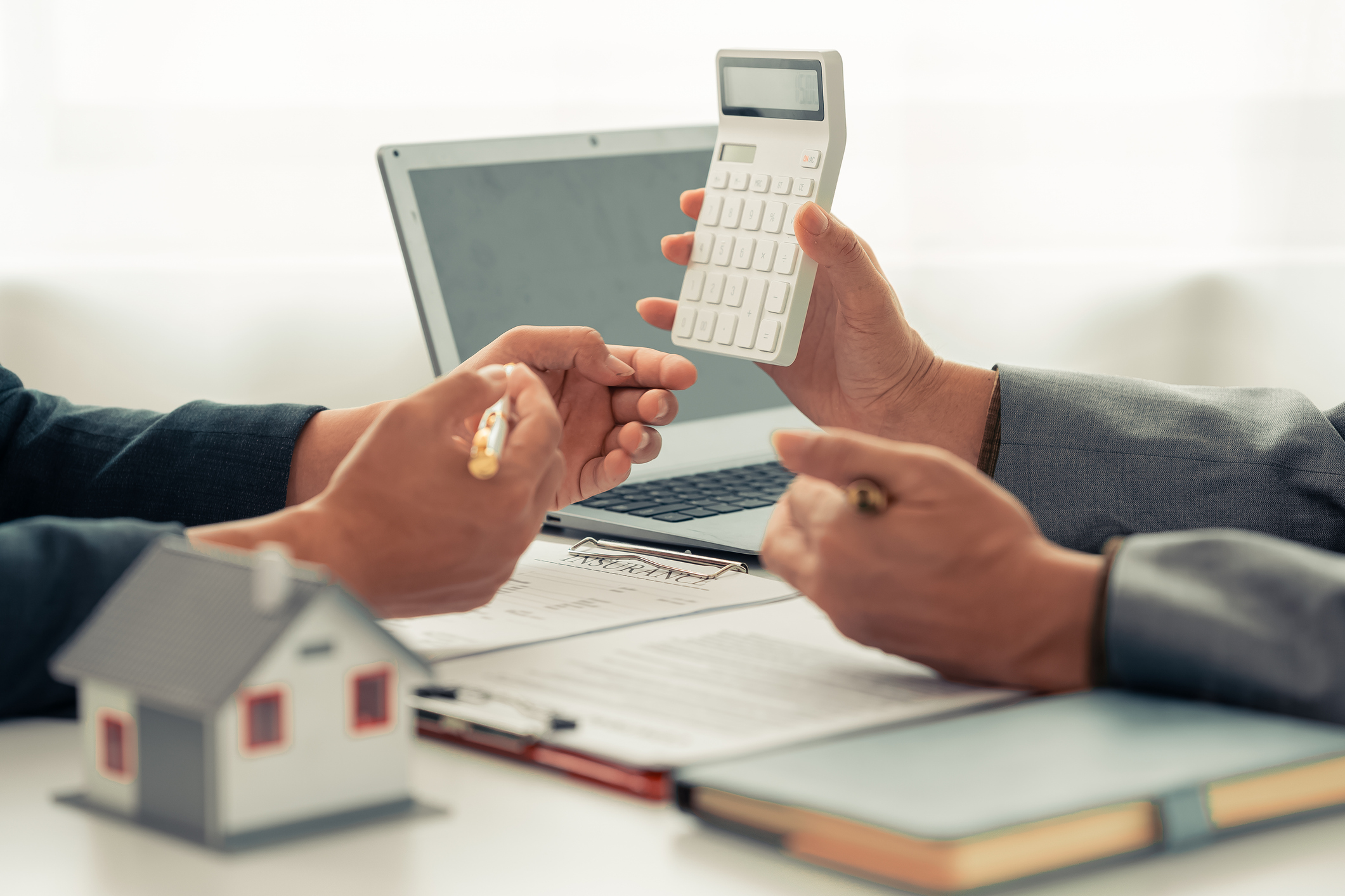 Someone showing numbers on a calculator to another.